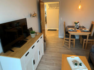 Das Wohnzimmer mit LED TV, Esstisch und Sofa