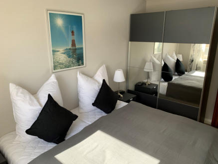 Das Schlafzimmer mit Doppelbett und großem Schrank